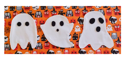 Three handmade ghost coasters sewn from white fabric with black eyes , easy Halloween sewing project